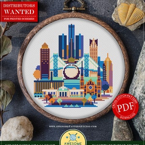 May include: Counted cross stitch pattern for Detroit, Michigan. The pattern features a colorful cityscape with skyscrapers, bridges, and a Ferris wheel. The pattern is 90 x 95 stitches and requires 18 colors of DMC thread.