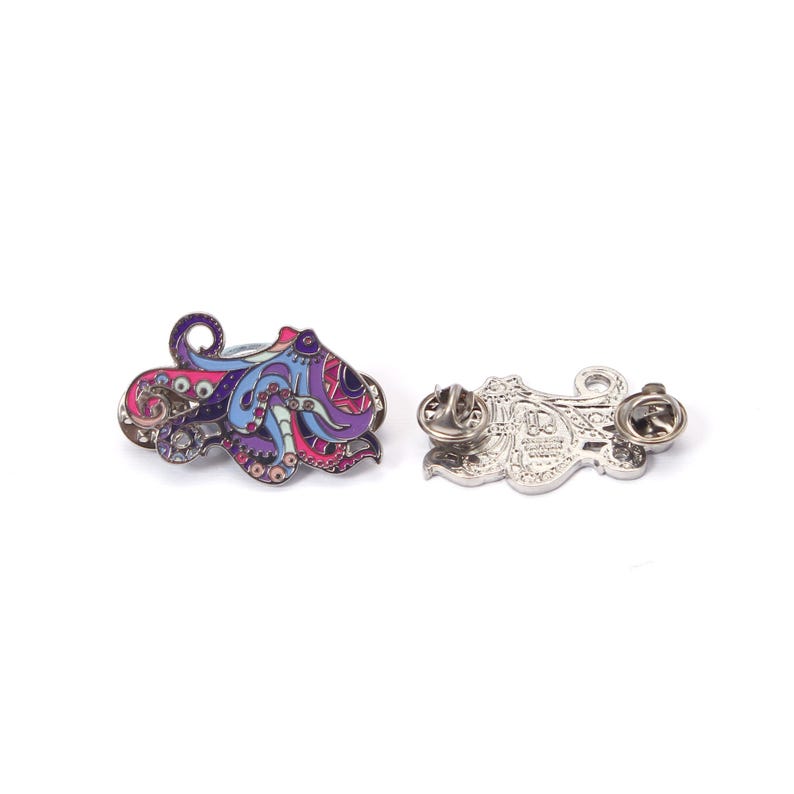 May include: Two octopus-shaped enamel pins. One pin features a colorful design with purple, blue, and pink hues. The other pin shows the back with two pin clasps. The pins are on a white background.