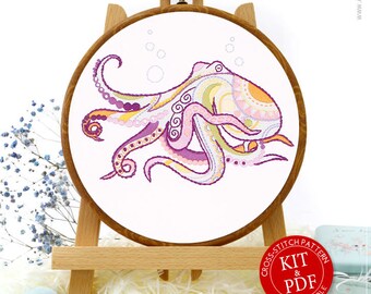 May include: A cross stitch pattern kit and PDF for a colorful octopus with a mandala design. The kit includes embroidery floss, a needle, and fabric. The PDF is customizable.