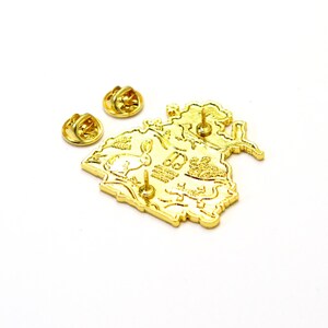 May include: Gold-tone enamel pin featuring a detailed illustration of a forest scene with a rabbit, mushrooms, and a bird. The pin has a back post and butterfly clutch.