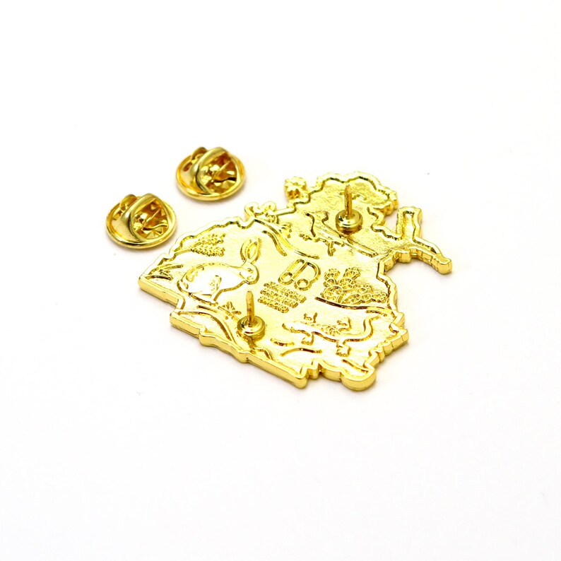 May include: Gold-tone enamel pin featuring a detailed illustration of a forest scene with a rabbit, mushrooms, and a bird. The pin has a back post and butterfly clutch.