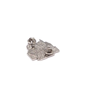 May include: A silver metal pin with a detailed, textured design. The pin has two pin backs for secure attachment. The design appears to be an abstract representation of a city or map. The pin is set against a white background.