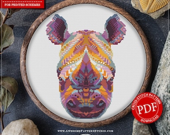 May include: A counted cross stitch pattern for a mandala rhino, featuring a colorful design with purple, orange, and blue hues. The pattern is available as a PDF download and is suitable for fabric Aida 16 count. The pattern measures 6.44 x 8.37 inches and requires 20 colors of DMC thread.
