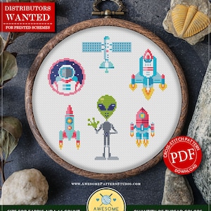 Pode incluir: Um padrão de ponto cruz em um bastidor de madeira com desenhos espaciais: um astronauta, foguetes, um satélite e um alienígena. O padrão é para download instantâneo e inclui o texto "In Space". O tamanho do tecido é de 16,51 x 17,14 cm.