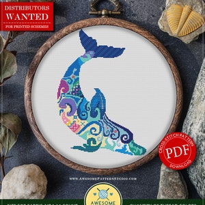 May include: A cross-stitch pattern of a dolphin in a wooden embroidery hoop. The dolphin is in shades of blue, teal, and purple with floral and geometric patterns. The text "Mandala Dolphin" and "PDF Download" are visible.
