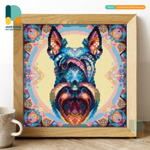 Op de afbeelding: Een ingelijst kruissteekkunstwerk met een gestileerd hondenportret. De kop van de hond is weergegeven in levendige blauwe, roze en oranje tinten tegen een lichtgele achtergrond. Het kunstwerk is ingelijst in een natuurlijke houten lijst, met de tekst "AWESOME PATTERN STUDIO".