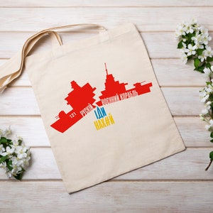 May include: A white tote bag with a red silhouette of a ship and the text "121 русский военный корабль ИДИ нах#й" printed on it.