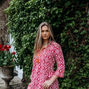 Made with pure organic cotton this is a vibrant pink knee length kaftan with beautiful detailing around the neck finished with two side pocket, this kaftan is ideal for just throwing on
