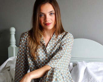 Könnte beinhalten: Eine Frau trägt einen blau-weißen Pyjama mit geometrischem Muster. Der Pyjama hat lange Ärmel und lange Hosen.