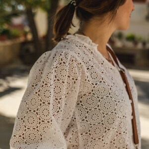 K&ouml;nnte beinhalten: Wei&szlig;e Blusenbluse mit zartem Muster. Die Bluse hat einen R&uuml;schenkragen und lange &Auml;rmel.