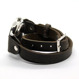 Peut inclure: Un bracelet de montre en cuir marron avec une boucle argent&eacute;e et un cadran de montre argent&eacute;.