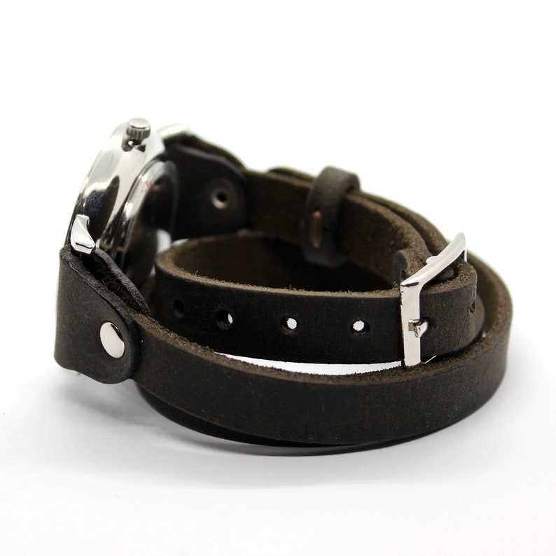 Peut inclure: Un bracelet de montre en cuir marron avec une boucle argent&eacute;e et un cadran de montre argent&eacute;.