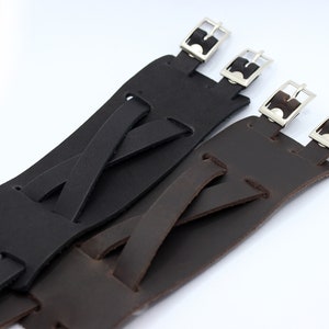 May include: Two leather watch straps with adjustable buckles. One strap is black and the other is brown.