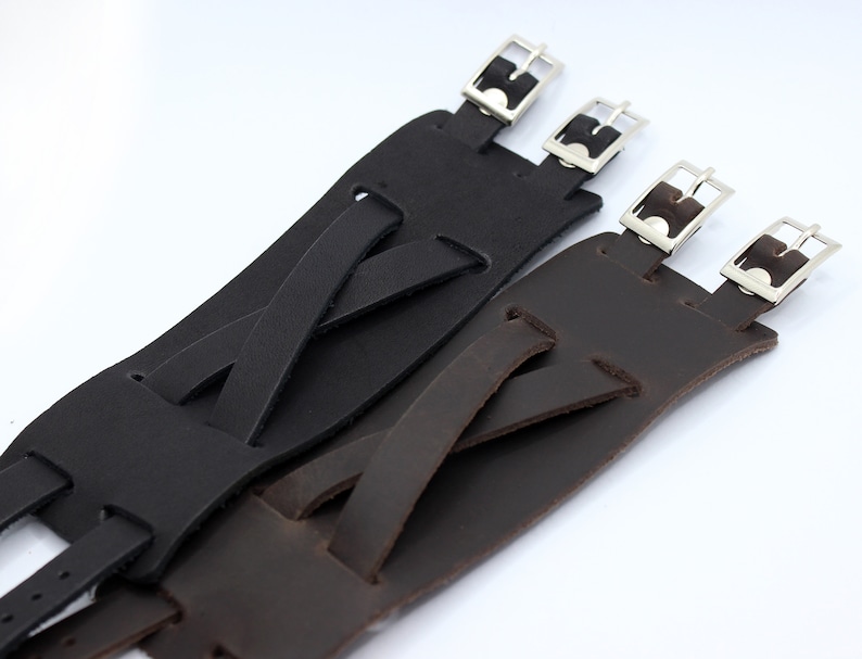 May include: Two leather watch straps with adjustable buckles. One strap is black and the other is brown.