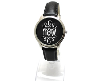 Reloj con estampado artístico NOW: Correa de cuero negro, regalo unisex motivacional.