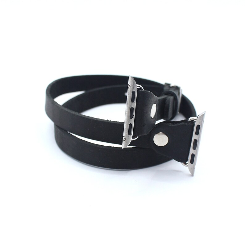 Peut inclure: Bracelet de montre Apple en cuir noir avec une boucle et un connecteur en m&eacute;tal argent&eacute;. Le bracelet est double.