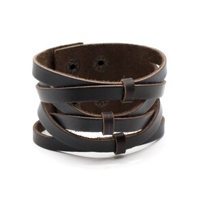 May include: A brown leather bracelet with multiple straps and metal accents.