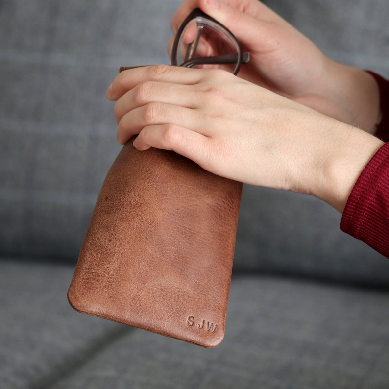 May include: Brown leather glasses case with the initials "SJW" embossed on the front.