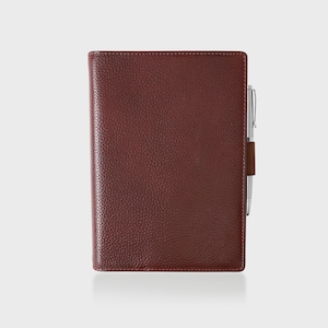 May include: A burgundy leather bound notebook with a silver pen holder and a silver pen.