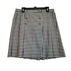 May include: A black and white gingham skirt with a pleated design. The skirt has decorative silver buttons and is suspended from a black hanger. The skirt is a classic style, suitable for various occasions.