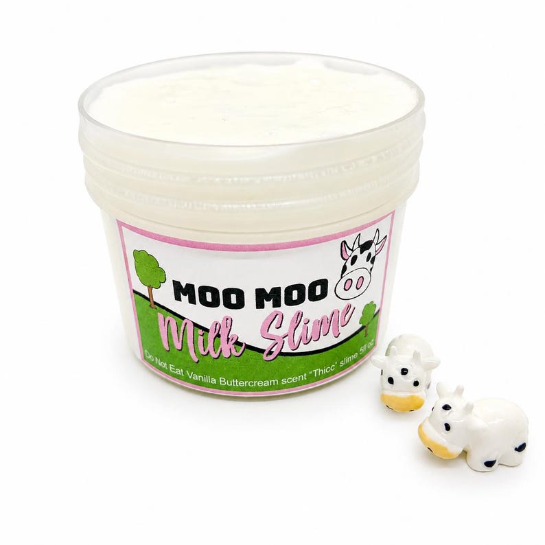 May include: A clear plastic container filled with white slime, featuring a label that reads MOO MOO Milk Slime, Vanilla Buttercream scent, Thicc slime 5 fl oz. Two small white and black cow figurines are placed next to the container.