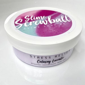May include: A white container of lavender-scented slime. The lid features a colorful design with the text "Slime Screwball SLIME SHOP UK." The label reads "Stress Relief Calming Lavender" with additional text about relaxation and butter slime.