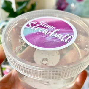 May include: A clear plastic container with a pink and purple label that says "Slime Screwball Slime Shop UK".