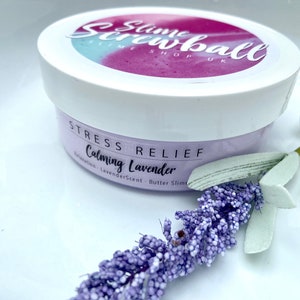 May include: A white jar of "Slime Screwball" butter slime with a lavender scent, labeled "Stress Relief" and "Calming Lavender." A sprig of lavender and a white surface complete the image.