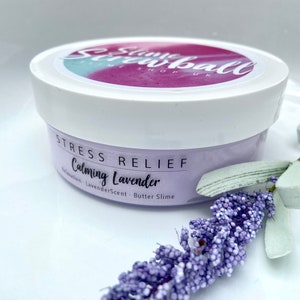 May include: A white jar of lavender-scented butter slime with the text "Stress Relief Calming Lavender". The jar is decorated with a sprig of lavender. The jar has a white lid with the text "Slime Screwball Shop UK".