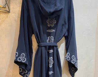 May include: A dark blue hooded robe with a white geometric pattern. The robe has a tie belt and long sleeves.