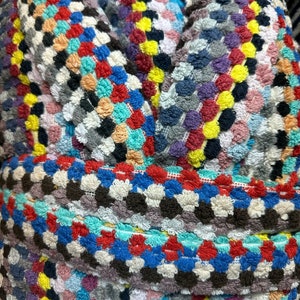 May include: A colourful, multi-textured bath towel with a variety of colours, including red, blue, yellow, green, and white. The towel is made of a soft, absorbent material and is perfect for drying off after a bath or shower.