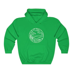 May include: A green hooded sweatshirt with a white outline of a circle containing the words "North Carolina" and "Esse Quam Videri" with a mountain and tree design.