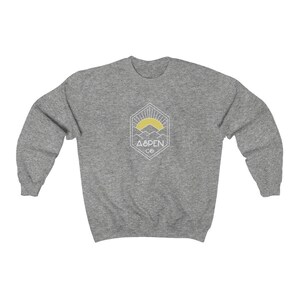 May include: A heather gray sweatshirt with a white graphic of a mountain range with a yellow sun rising behind it. The graphic is inside a geometric shape and says "Aspen Co."