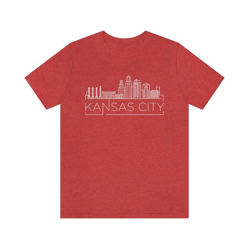 May include: Red heather t-shirt with a white outline of the Kansas City skyline and the text "KANSAS CITY" in a white box.