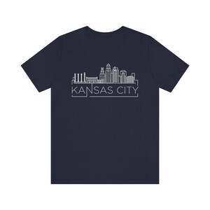 May include: A navy blue t-shirt with a white outline of the Kansas City skyline and the text "KANSAS CITY" underneath.