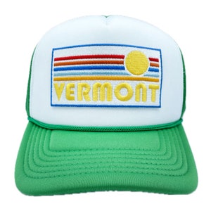 May include: A white and green trucker hat with a colorful sunset and the word "VERMONT" embroidered on the front.