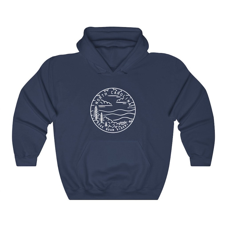 May include: Navy blue hooded sweatshirt with a white outline of a circle containing the words "North Carolina" and the state motto "Esse Quam Videri" with a mountain and tree landscape inside the circle.