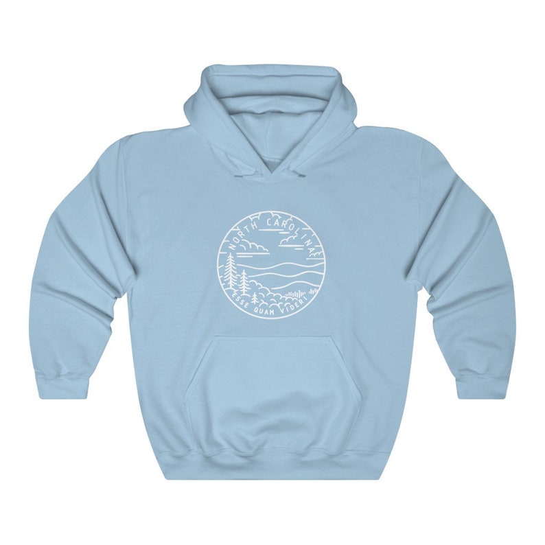 May include: Light blue hooded sweatshirt with a white outline of a circle containing the words "North Carolina" and the state motto "Esse Quam Videri" with a mountain and tree landscape inside the circle.