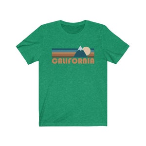 May include: A green t-shirt with a retro-style graphic of a mountain range, sun, and the word "CALIFORNIA" in orange.