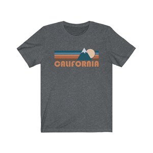 May include: A dark heather grey t-shirt with a retro-style graphic of a mountain, sun, and the word "CALIFORNIA" in orange.