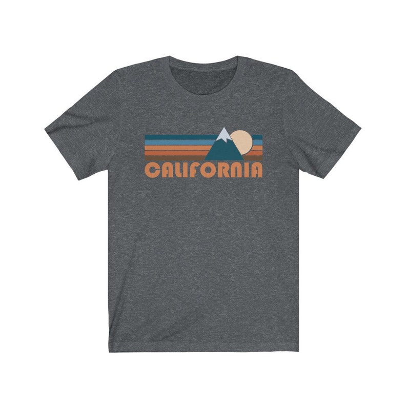 May include: A dark heather grey t-shirt with a retro-style graphic of a mountain, sun, and the word "CALIFORNIA" in orange.