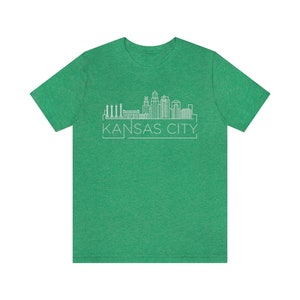 May include: A green t-shirt with a white outline of the Kansas City skyline and the text "KANSAS CITY" underneath.
