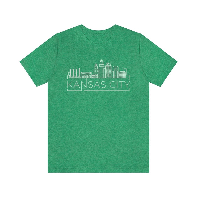 May include: A green t-shirt with a white outline of the Kansas City skyline and the text "KANSAS CITY" underneath.