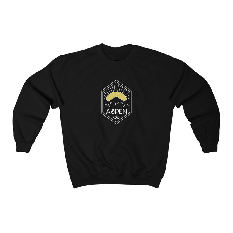 May include: Black sweatshirt with a white graphic of a mountain range with a sun rising behind it. The graphic is inside a hexagon with the text "ASPEN CO" below it.