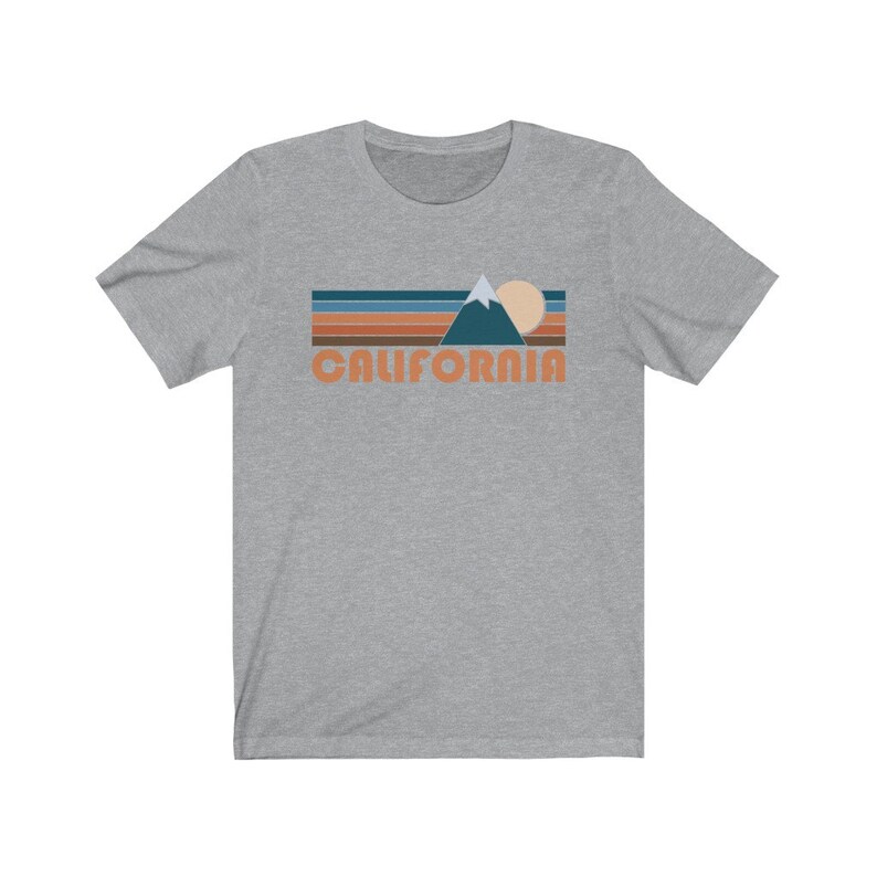 May include: A heather gray t-shirt with a retro-style graphic of a mountain range, sun, and the word "CALIFORNIA" in orange.