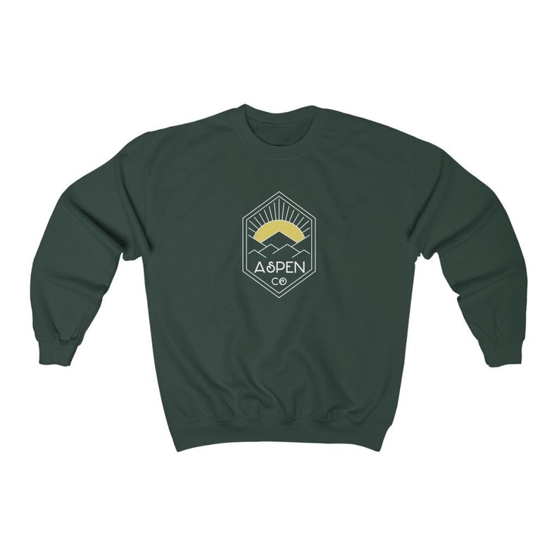 May include: A dark green sweatshirt with a white logo featuring a mountain range and a sun with the text "ASPEN CO" in a hexagon.
