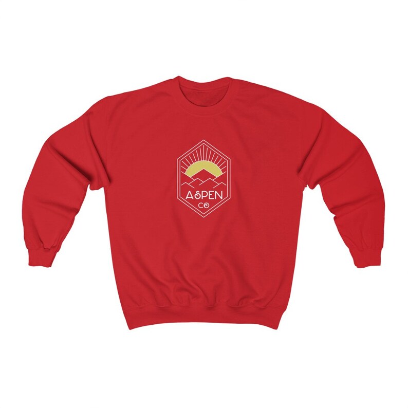 May include: Red sweatshirt with a white graphic of a mountain range with a sun rising behind it. The graphic is inside a hexagon with the text "ASPEN CO" below it.