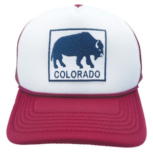 May include: A white and red trucker hat with a blue embroidered buffalo and the word "COLORADO" on the front.