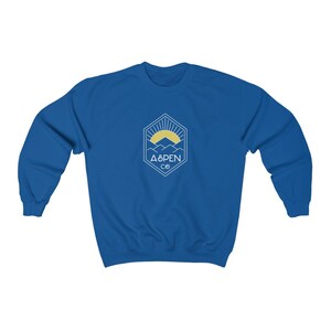 May include: A royal blue sweatshirt with a white graphic of a mountain range with a sun rising behind it. The graphic is inside a hexagon with the text "ASPEN CO" below it.