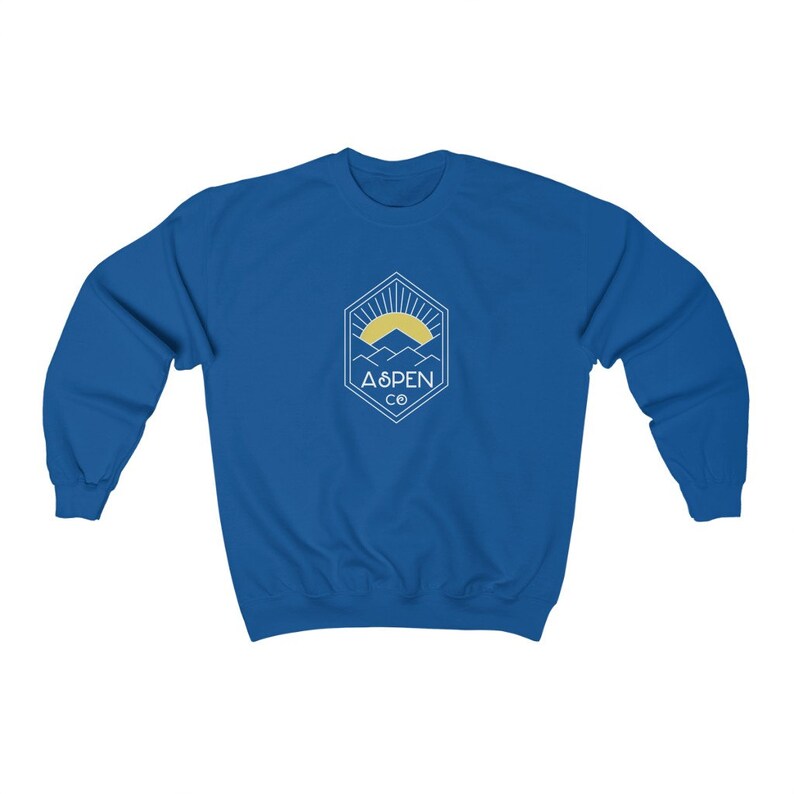May include: A royal blue sweatshirt with a white graphic of a mountain range with a sun rising behind it. The graphic is inside a hexagon with the text "ASPEN CO" below it.